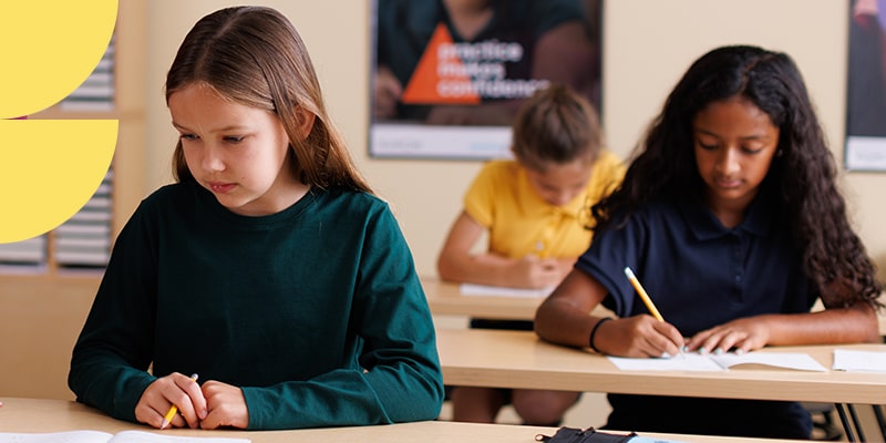 Three students doing worksheets in a learning center franchise location